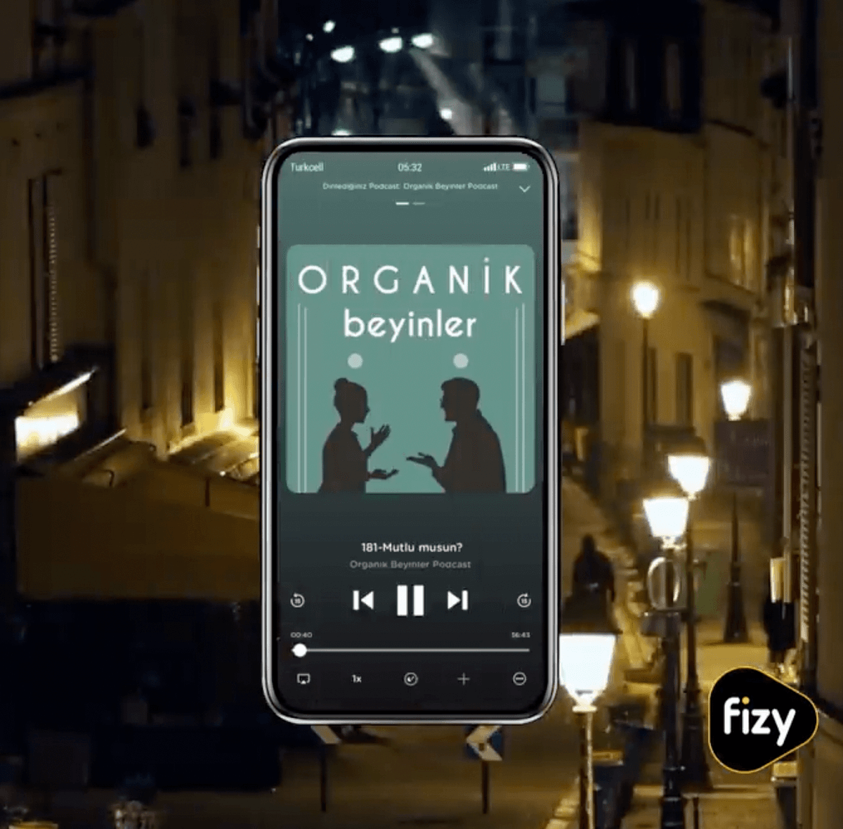 fizy playing a podcast on a phone, on a street at night